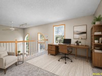 Home office setup on Wiedman Way, Eden Prairie, featuring a desk with computer, office chair, armchair, bookshelves, and a large window. "Virtually staged" appears in the bottom right corner. Listing ID: 17595. - Beise Real Estate